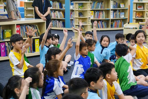 Primary students with their hands up during a workshop